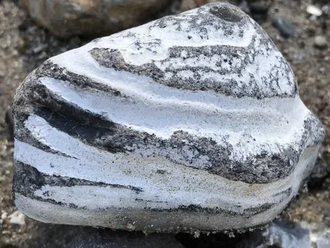 Close-up of beautiful layered triangular stone rock in white and grey stripes  Stock Photos