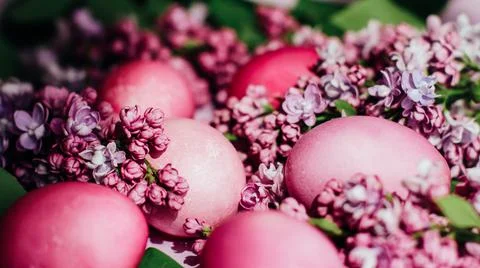 Close-up of beautiful lilac Easter eggs with blooming lilac branches. Easter Photos