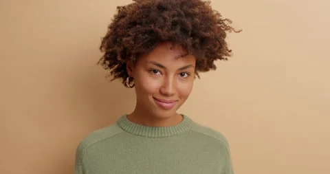 Close up of beautiful mysterious young Afro American woman looks directly at Stock Footage 142324729
