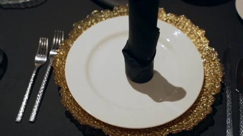 Close-up of a beautiful table setting with a gold plate and black tablecloth Stock Footage 172388833