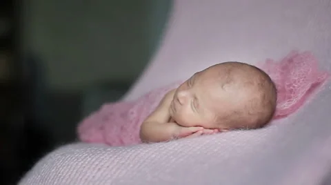 Close up of beautiful tiny newborn baby girl sleeping on a pink knitted blank Stock Footage 50153257