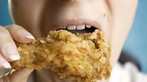 Close-up beautiful woman eats, fast food, chicken nuggets, wings and chicken leg Stock Footage 128242519