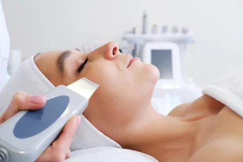 Close-up of beautiful woman's face during ultrasonic peel skin procedure at s Stock Photos