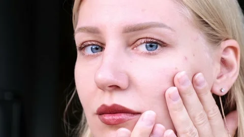 Close-up of beautiful woman's face. Young blue-eyed blonde girl touches her face Stock-Footage 213157358