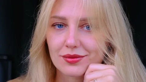 Close-up of beautiful woman's face. Young blue-eyed smiling blonde girl looking Stock-Footage 218575158