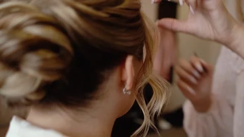 Close-up of a beautiful young bride getting her hair done and hanging her veil Stock Footage 256993940