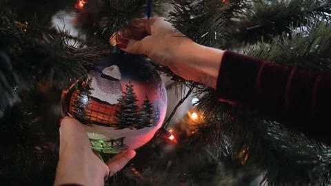 Close up of beautiful young lady hands decorate the Christmas tree with big ball Stock Footage 70761354