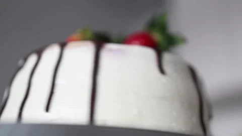 A close-up of a beautifully decorated cake with smooth white icing and a drizzle Stock Footage 302794899