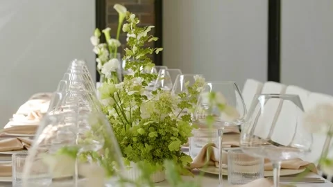 Close-up of a beautifully set dining table with floral centerpieces and candles. 스톡 동영상 288104291