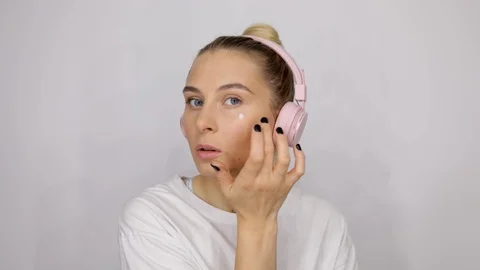 Close up beauty blondie model applying bb cream to her cheeks professional Stock Footage 112663379