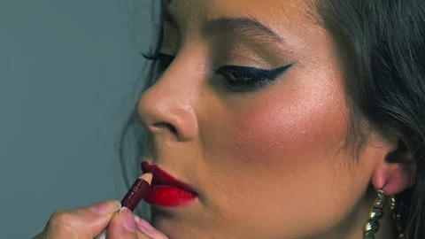 Close-up of a beauty model during a glamorous makeover. Red lipstick is applied  Stock Footage 313754153
