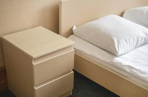 Close-up of the bed and bedside table, modern and bright interior of the bedroom Stock Photos