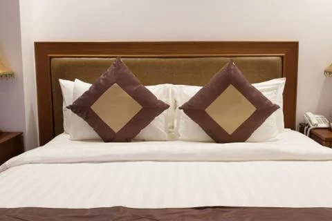 Close up bed with bedding sheet and two pillows in hotel room Stock Photos