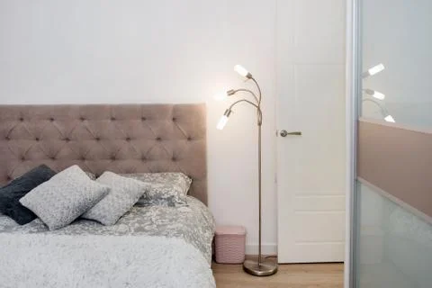 Close up of a bed with colored pillows, bedspread and a cozy lamp. Loft inter Stock Photos