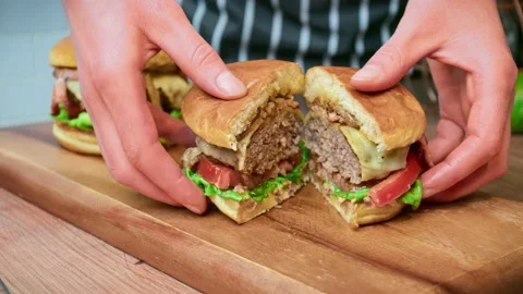 Close-up beef burger being sliced in half on the table in 4K. Stock Footage 153762610