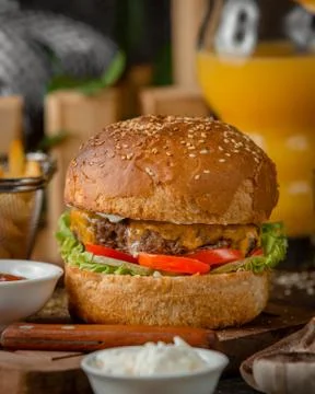 Close up of beef burger with melted cheddar, tomato, lettuce and mayo Stock Photos