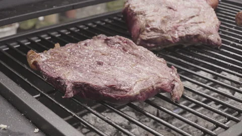 Close up on beef in the heat of the grill, ashes flying Stock Footage 138540211
