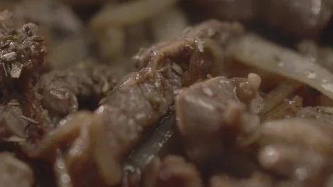Close-up of beef with onions fried in frying pan. Chef throws spices Stock Footage 114979538