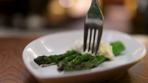 Close up of a beef steak with asparagus and a piece of lemon on a black plate Stock Footage 302092408