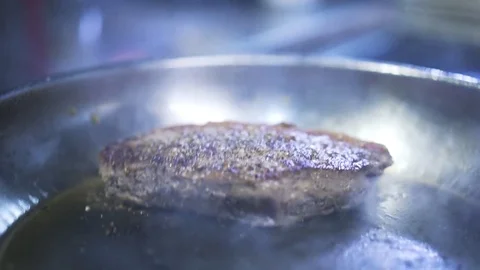 Close up of a beef steak being fried in a pan 库存影片 76717878