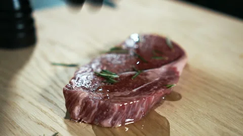 Close up of beef steak is being turned around by the hand in black glove, slow Video stock 88571766