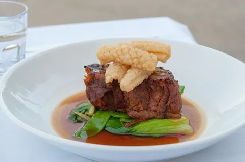 Close up of beef steak with seared scallops, calamari and green vegetables Stock Photos