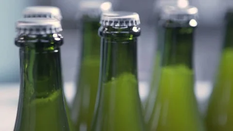 Close-up of beer bottles moving on conveyor belt in brewery Stock Footage