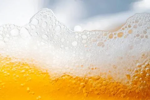 Close-up of beer foam with bubbles and golden liquid Stock Photos