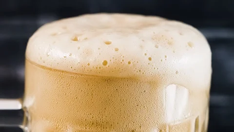 Close-up of beer foam flowing down a glass. Stock Footage 123537447