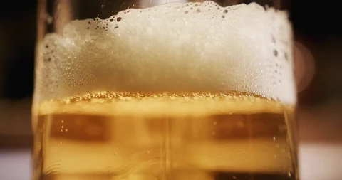Close up of beer foam moving down and bubbles. Cold Light Beer in a glass 4K Stock-Footage 115955992