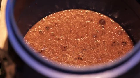 Close up of beer mash fermenting inside a home brewing bucket Stock Footage 345681008