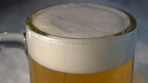 Close Up of Beer in a Mug surrounded by Snow and Ice Bubbling in Slow Motion. Stock Footage 98055683