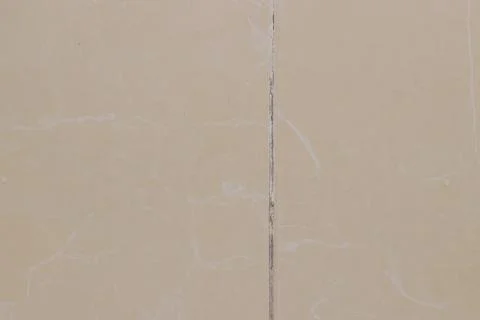 Close-up of beige ceramic tiles with dark traces of mold and dirt in the jo.. Stock Photos