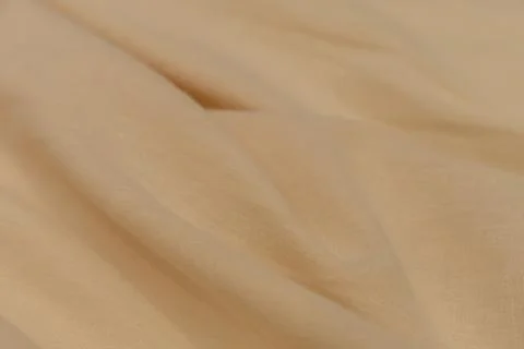 Close-up of beige fabric with soft texture and gentle folds Stock Photos