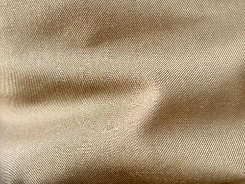 Close-up of beige fabric with visible texture and folds Stock Photos