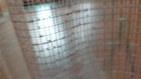 Close-up of beige mesh curtain fabric texture moving gently 库存影片 336901087