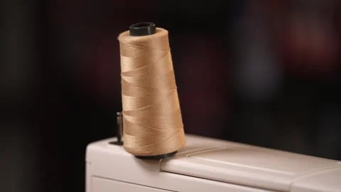 Close-Up of Beige Sewing Thread on Machine Stock Footage 320076819