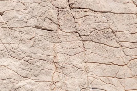 Close-up of beige textured rock surface with natural cracks Stock Photos