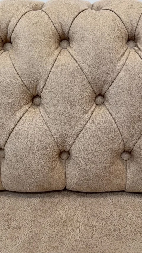 Close-up of beige upholstered tufted sofa fabric surface with button detail.. Stock Footage 336555890