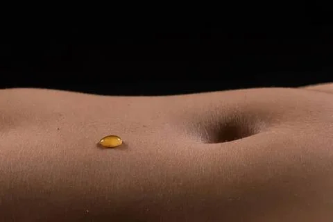 Close-up of a belly button and a small yellow object on skin Stock Photos