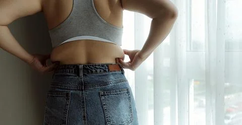 Close up of a belly with scar from c-section and abdominal fat. Women's hea.. Stock Photos
