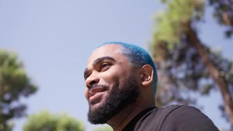 Close-up from below of black man talking to someone chilling 스톡 동영상 287488379