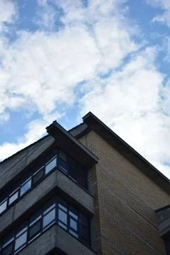 Close up from below on a building and a cloudy sky above Stock Photos