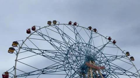 Close-up from below of a Ferris wheel against a clear blue sky. Traveling with Stock Footage 279468577