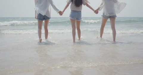 Close up Best Friends group of young women holding hands walking to sea beach Stock Footage