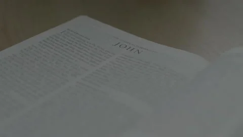 Close up of Bible Opened to the Book of John on Table in Natural Light Stock Footage 208786794