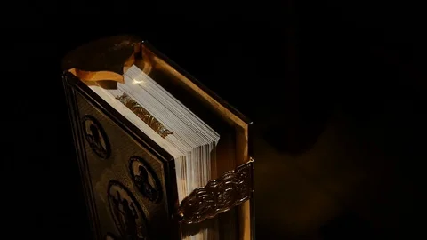 Close-up of the Bible in the sun on a black background Vídeos de archivo 129372952