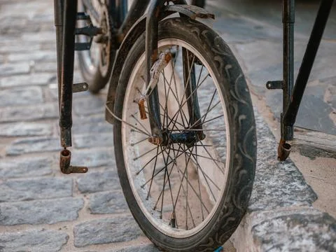 Close-up of a bicycle front wheel on stone pavement in an urban street Foto stock