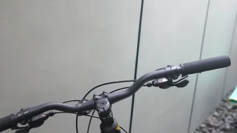 Close-up of a bicycle handlebar featuring a striking yellow and black grip, show Video stock 301582452