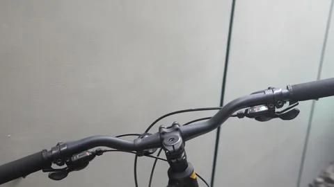 Close-up of a bicycle handlebar featuring a striking yellow and black grip, show Video stock 301582500